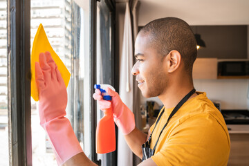 Wall Mural - Male housekeeper cleaning glass window at home.