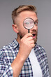 © kegfire - Curious man with magnifying glass looking at camera