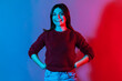 © khosrork - Neon light portrait of happy lovely beautiful brunette woman in pullover standing confident and looking at camera with toothy smile, enjoying life, positive outlook. indoor studio shot isolated
