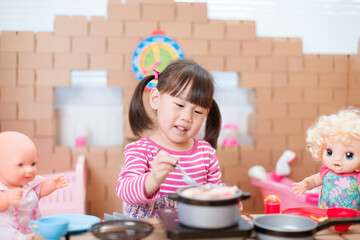 Wall Mural - toddler girl pretend play babysitting with baby doll at home