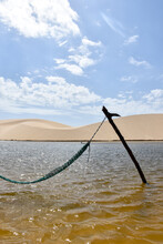 A Rustic Hammock In A Lagoon Surrounded By Sand Dunes, In Lençóis Maranhenses, Brazil.