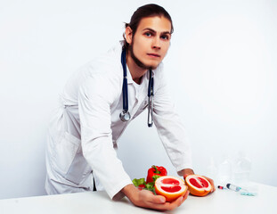 young pretty doctor with stethoscope holding fruits, healthy food care concept