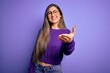 © Krakenimages.com - Young beautiful smart woman wearing glasses over purple isolated background smiling cheerful offering palm hand giving assistance and acceptance.