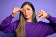 © Krakenimages.com - Young beautiful brunette woman holding healthy chocolate cookie over eye with angry face, negative sign showing dislike with thumbs down, rejection concept