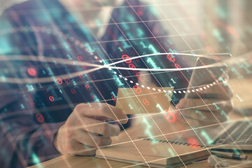 Double exposure of man's hands holding and using a phone and financial graph drawing. Analysis concept.