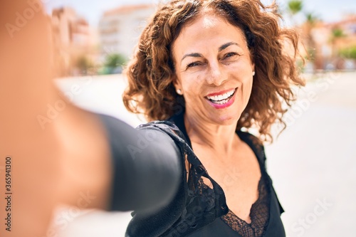 Cuadros en Lienzo Middle age beautiful brunette woman smiling happy and confident