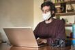 © Jose - Photographer with covid protective mask working from his notebook