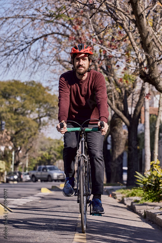 Young man on bicycle with protective mask against covid 19 driving on bike lane