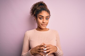 young beautiful african american girl wearing casual sweater standing over pink background hands tog