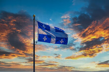 The Flag Of Quebec Flying Against The Sky
