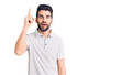 © Krakenimages.com - Young handsome man with beard wearing casual polo pointing finger up with successful idea. exited and happy. number one.