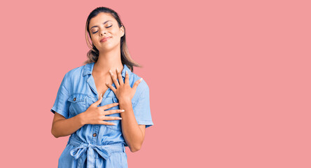 Young beautiful woman wearing casual clothes smiling with hands on chest with closed eyes and grateful gesture on face. health concept.