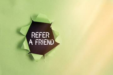 Poster - Writing note showing Refer A Friend. Business concept for direct someone to another or send him something like a gift Rolled ripped torn cardboard above a wooden classic table