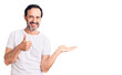 Middle age handsome man wearing casual t-shirt showing palm hand and doing ok gesture with thumbs up, smiling happy and cheerful