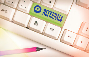 Poster - Text sign showing Referrals. Business photo showcasing someone or something to research study or take any further action Different colored keyboard key with accessories arranged on empty copy space