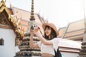 Wall Mural - Happy young asian woman backpack local travel and take a photo with camera.