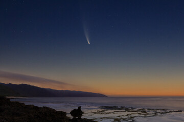 Wall Mural - comet neowise at dawn over coastal tide pools in the foreground and wisps of clouds over the mountai