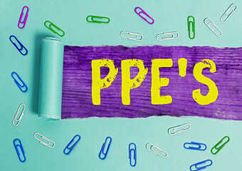 Poster - Handwriting text Ppe s is. Conceptual photo Specialized equipment for protection against health and safety hazard Rolled ripped torn cardboard placed above a wooden classic table backdrop