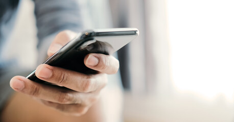 Close up man using smart phone at home