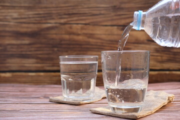 Sticker - Drinking water on wooden table background and space for text 