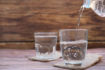 Wall Mural - glass of water on wooden table