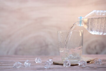 Wall Mural - Pouring drinking water on wooden table background and space for text 