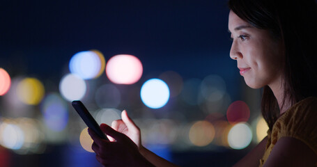 Wall Mural - Woman use of cellphone over city night view