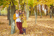 © Studio Romantic - Family with daughter stand under yellow tree in park in autumn.