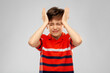 © Syda Productions - childhood, fashion and people concept - portrait of stressed boy in red polo t-shirt having headache over grey background