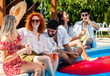 © Zoran Zeremski - Group of young people having fun at summer vacation and enjoying a poolside party with drinks.
