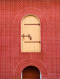 Fototapeta Desenie - Vintage wooden door painted light yellow on red brick wall background
