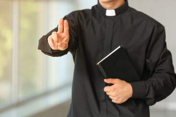 Male priest with Bible at home