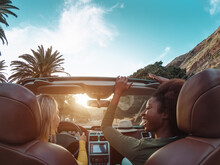Young Happy Women Doing A Road Trip In Tropical City - Travel People Having Fun Driving In Trendy Convertible Car Discovering New Places - Friendship And Youth Girlfriends Vacation Lifestyle Concept