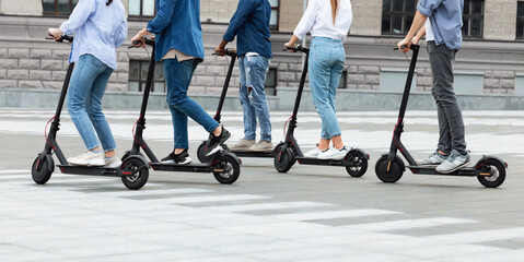 Friends having ride on motorized kick scooters