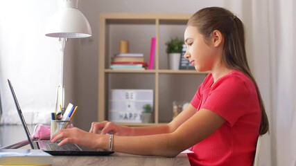 Poster - children, education and learning concept - teenage student girl with laptop computer writing to notebook at home