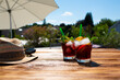 Summer drink on sunny terrace
Fresh cold summer drink on sunny terrace with parasol and straw hat on wooden table. Background for vacation and leisure. Short depth of field.