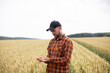 © Yevhenii Kukulka - A farmer in a checkered orange shirt stands in a wheat field