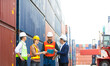 © NVB Stocker - Group of professional dock worker and engineering people wearing hardhat safety helmet and safety vest standing and working at container yard port of import and export. Business teamwork concept