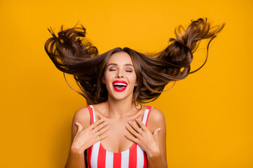 Wall Mural - Photo of lovely funny lady throw wind flight long hairdo having fun exotic ocean resort laughing good mood seashore wear white red striped bodysuit isolated bright yellow color background