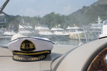 White Sea Captain's Cap On The Dashboard Of The Boat