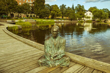 Bronze Buddha Statue On The Shore Of The Lake.