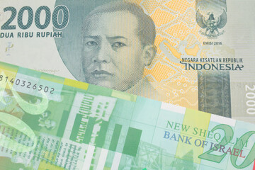 A macro image of a grey two thousand Indonesian rupiah bank note paired up with a green and white fifty shekel bank note from Israel.  Shot close up in macro.