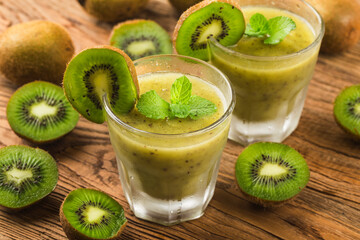 Poster - glass of kiwi juice with fresh fruits on wooden table