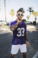 Wall Mural - Young European hip male in street style sporty outfit with sunglasses and tattoos on his arms