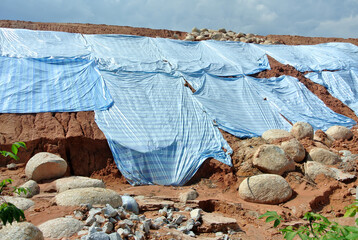 Wall Mural - SEREMBAN, MALASIA - MARCH 3, 2019: The plastic sheet is spread over the surface of the slope to prevent erosion. Also to temporarily stabilize the slope before the permanent stabilization work done.