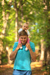 © Sk Elena - The child sits on his fathers shoulders. Father and baby walking in the park. Summer time. Happy family spent time together outdoors.