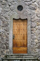 Sticker - Vertical shot of an old concrete building with a wooden door