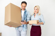 © Angelov - people, delivery, shipping and postal service concept - happy couple opening cardboard box or parcel at home