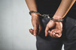 © methaphum - Prisoner male criminal standing in handcuffs with hands behind back.