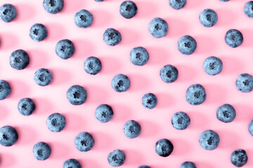 Fresh berries blueberry on pink background. Colorful fruit pattern of blueberries as background. Creative berries concept. Flat lay, top view, copy space